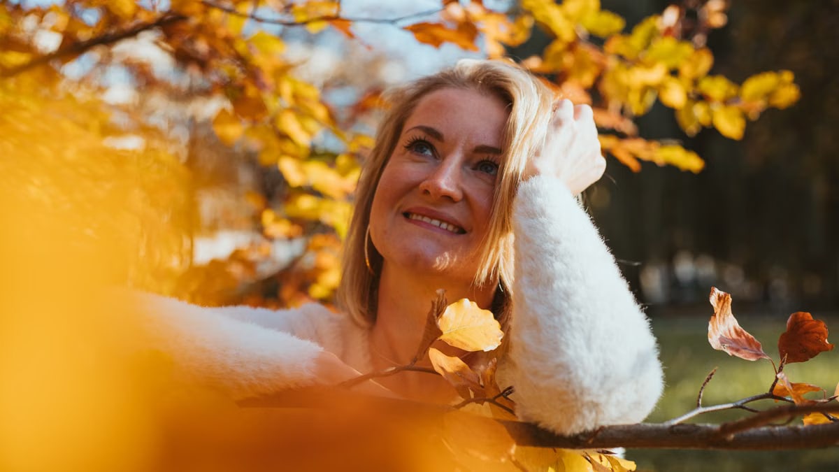 A woman enjoying the autumn scenery in Munich, Bavaria, surrounded by golden leaves.
